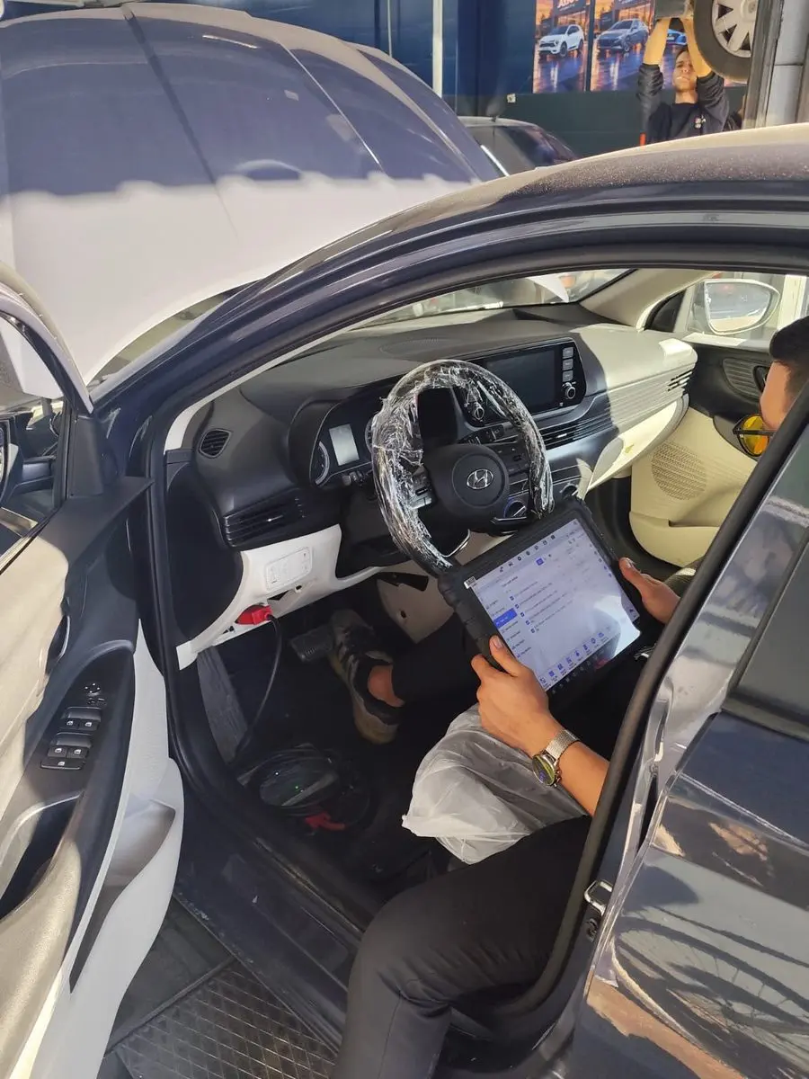 Hyundai'nin sürücü koltuğunda Autel arıza tespit tabletiyle çalışan usta