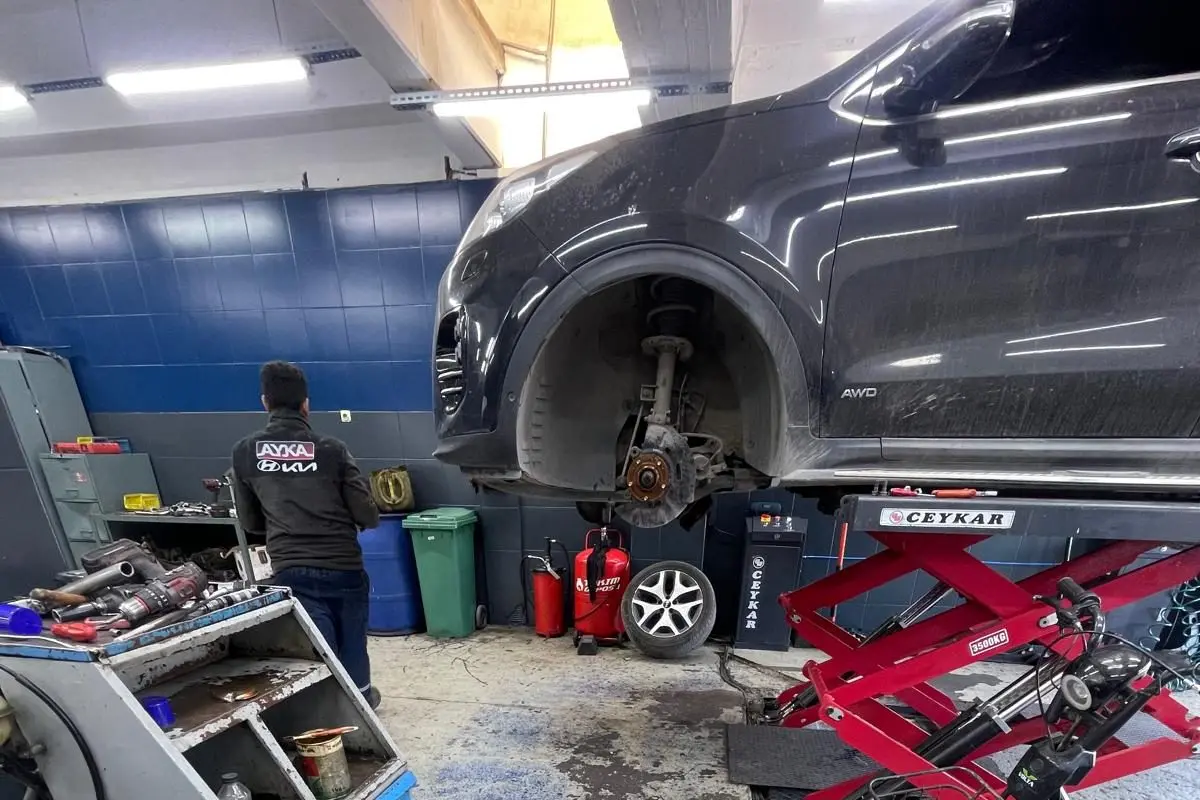 Ayka Otomotiv atölyesinde ön tekerleği sökülmüş, lift üzerinde kontrol edilen araç