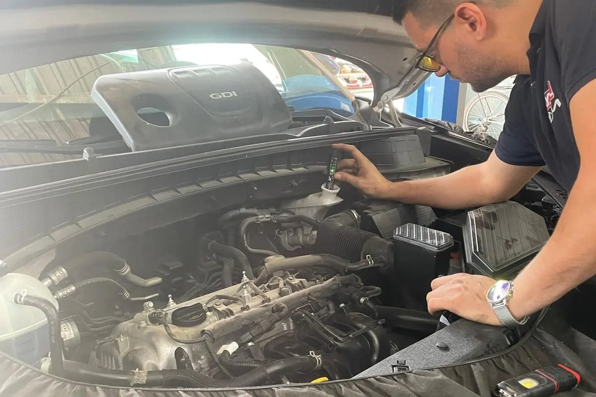 Ayka Otomotiv'de bakım sırasında GDi motorlu aracın motor bölmesinde sıvı ölçümü yapan usta